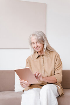 Positive aged female using tablet at home