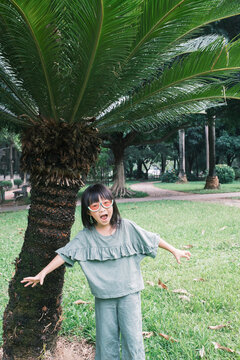 Portrait Of Cute Little Girl And Palm Tree