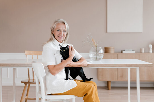 Middle aged woman with cat looking at camera