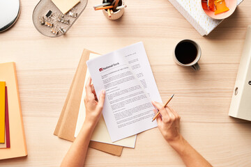 Unrecognizable employee doing paperwork at table