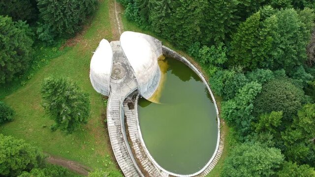 Bojiste, Bosnia and Herzegovina - July 15, 2019 Concrete monument Spomenik na Korcanici in Grmec mountain - zoom out with move up above green wood