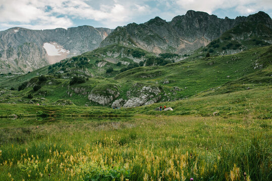 Mountain range with a mountain lake with tourists in the distance
