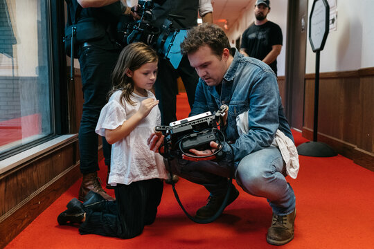 Director and young girl reviewing video monitor