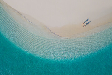 A Couple walking on a maldivian beach seen from above