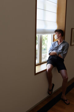 Young man indoors with mandatory facial mask