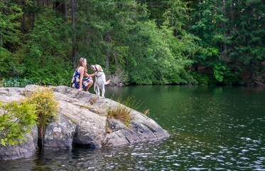 Child with her dog on a scenic rock outcropping- Thetis lake,  greater Victoria, Vancouver island, British Columbia, Canada 