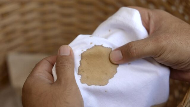 A white cotton shirt stained with brown coffee stains. Must be washed thoroughly in the washing machine
