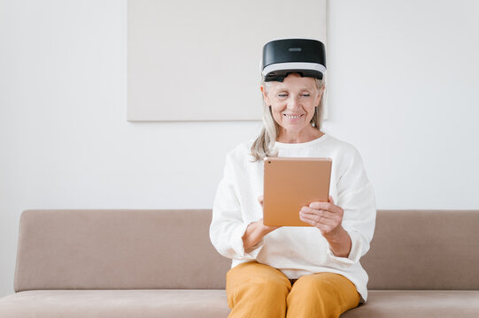 Elderly woman with VR glasses using tablet