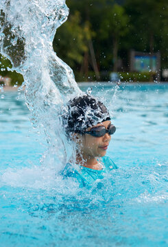 Beautiful Asian girl playing with water splashing in swimming pool in spa