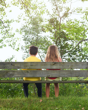 Children Sitting Together on Wood Bench Outside