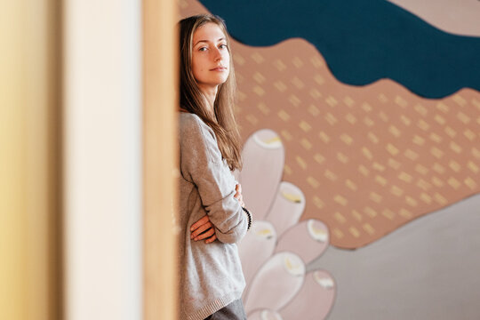 Young woman resting near painted wall