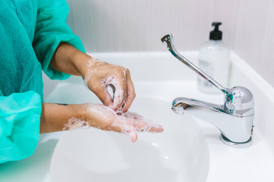 Anonymous person washing hands in clinic