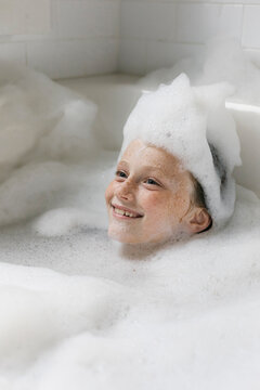 Portrait of Happy Young Child Taking a Bubble Bath