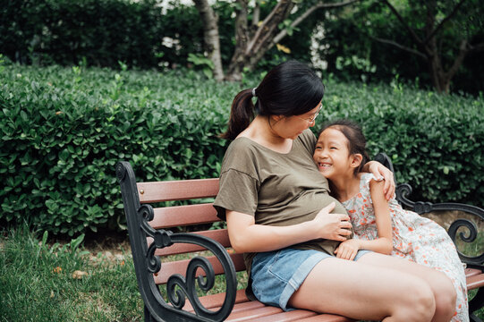 Pregnant woman with daughter in the park