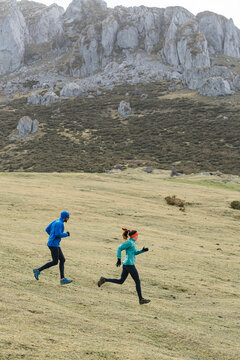 Couple running workingout on mountain trail in winter day