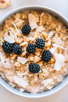 Homemade porridge topped with wild blackberries, walnuts and shr