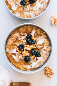 Homemade porridge topped with wild blackberries, walnuts and shr
