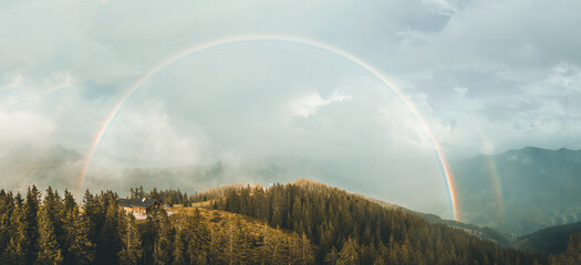 huge rainbow in misty alps