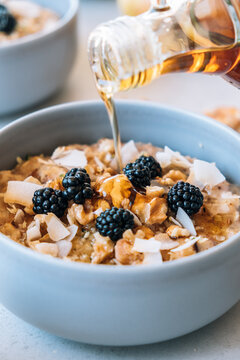 Homemade porridge topped with wild blackberries, walnuts and shr