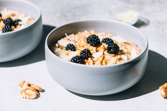 Homemade porridge topped with wild blackberries, walnuts and shr
