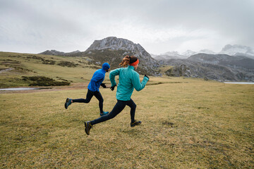 Couple of runners in mountains in winter