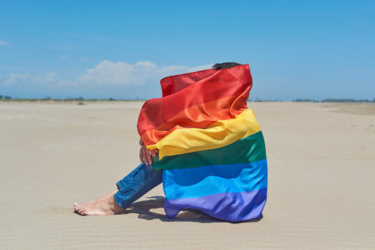 person wrapped in a rainbow flag