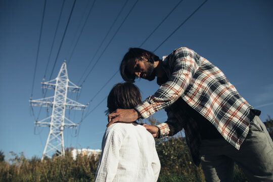 Father and little son at the power line tower