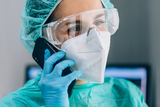 Happy surgeon talking on cellphone during a break at work