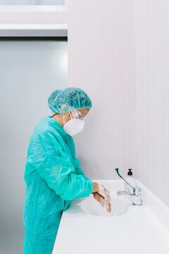 Surgeon woman in medic uniform washing hands in clinic