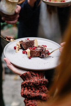 sharing a Christmas dessert with chocolate and red berries outdoors with a fire pit