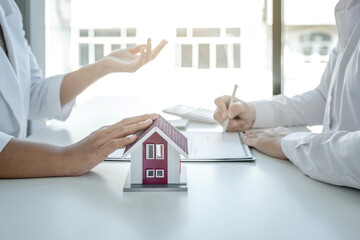 hand. The real estate agent explains the business contract, rent, purchase, mortgage, a loan, or...