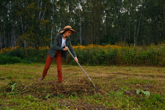 Female farmer cleaning field from grass
