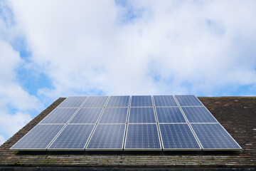 Solar photovoltaic panels on a clay tile roof in England, United Kingdom, with copy space