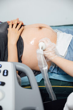 Doctor performing ultrasound on pregnant woman