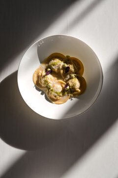 modern food in bar. ravioli with salmon, shrimp, onion, peas, Parmesan