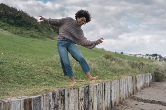 Smiling Black Woman Balancing on the fence