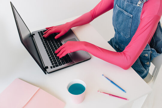 Unrecognizable person in colorful outfit working on laptop