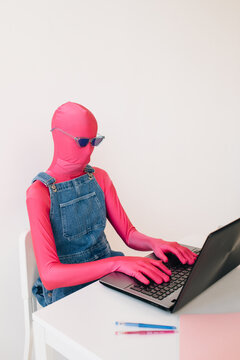 Unrecognizable person in colorful outfit working on laptop