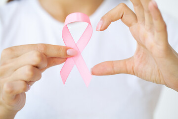 Close up of woman showing pink ribbon symbolizing breast cancer