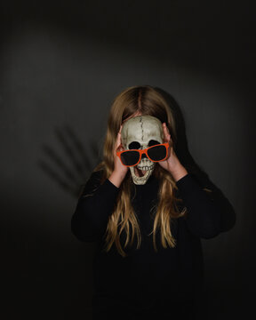 Child Holding Halloween Skeleton Face
