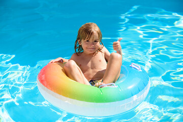 Children playing in the swimming pool with floating ring.