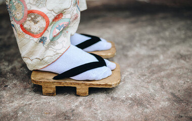 Close up of Japanese woman standing while wearing traditional Japanese footwear (called 'Geta')....