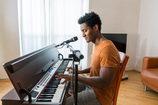 Man Playing Piano And Singing At Home
