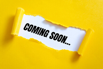 Text COMING SOON appearing behind torn yellow paper. For your design, concept.
