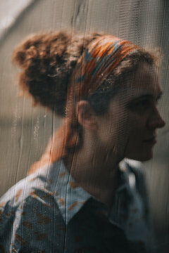 A Portrait of a beautiful woman behind a curtain