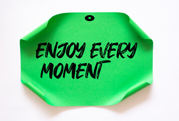 Enjoy every moment write on green Sticky Notes.