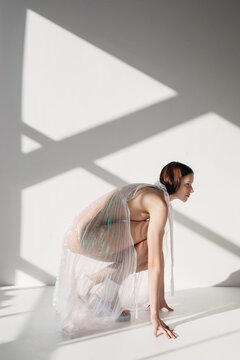 Female model in transparent plastic garment in studio
