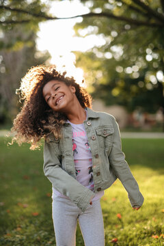 A beautiful, young african american child playing around her front yard and having fun