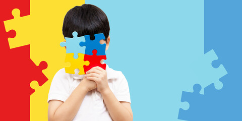 World autism awareness day April 2 - Studio Portrait of a cute asian boy cover his face with the colorful puzzles pieces. Autism Spectrum Disorder concept, ASD, Syndrome, Light it up blue, Backdrop. - obrazy, fototapety, plakaty