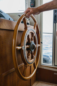 Boat Captain with Hand on Steering Wheel